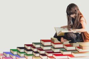 girl reading on a pile of books