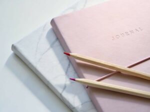 pink bullet journal and colored pencils