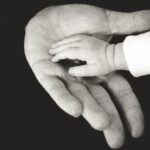 baby's hand in paren's hand, black and white